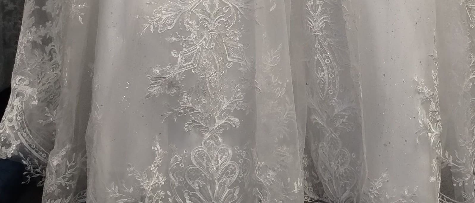 Ivory lace appliqués across the tulle skirt of a ball gown