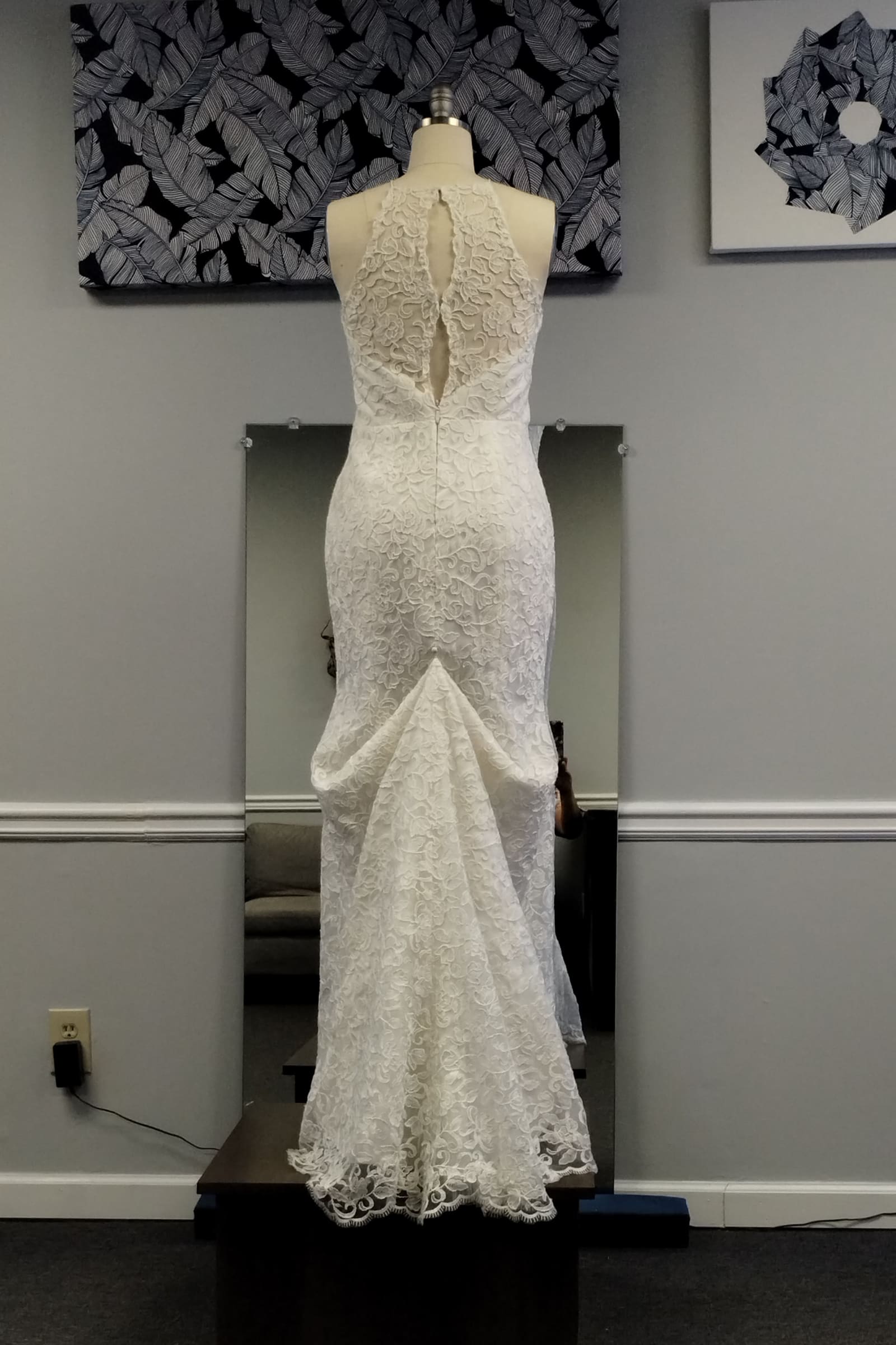 Back of an ivory lace mermaid wedding dress with a bustled train