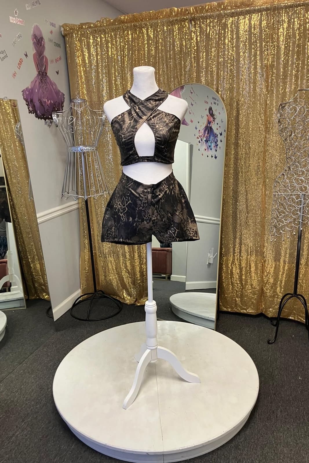 Black and gold brocade two-piece, a crossed halter top and tailored shorts, on a dress form