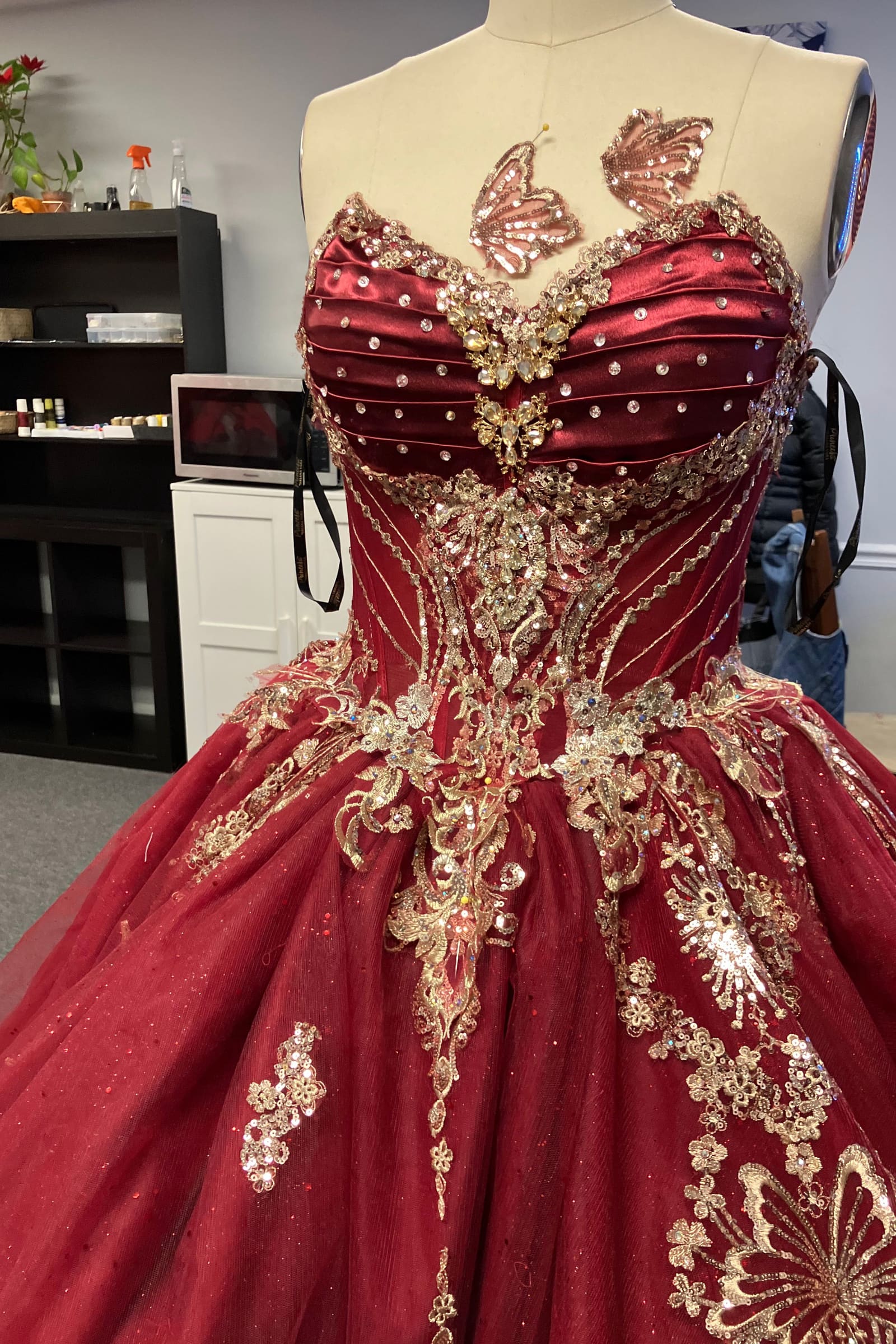 Burgundy corset bodice with gold beaded embellishment on a full skirt