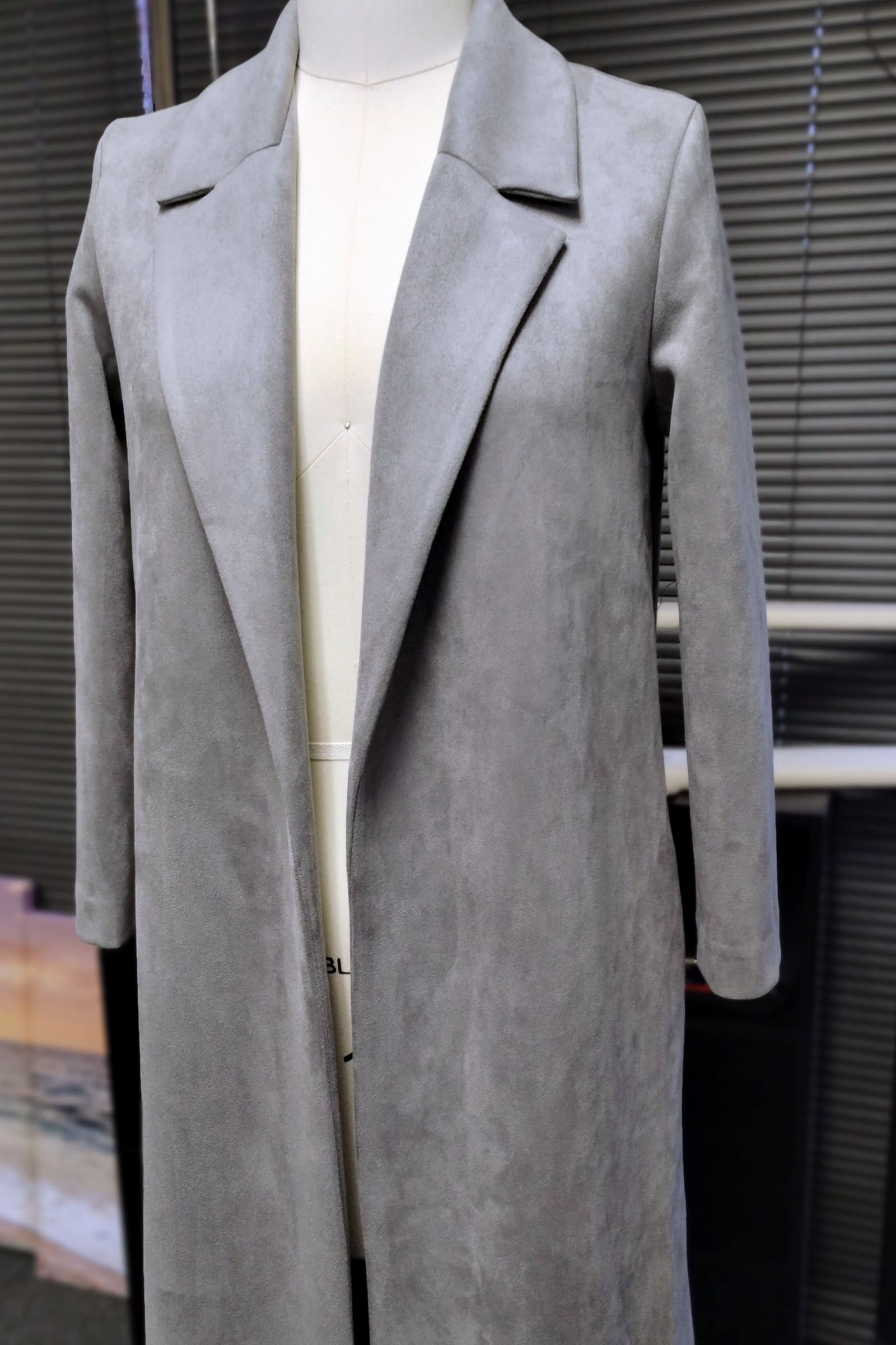 Long grey coat with notched lapels on a dress form