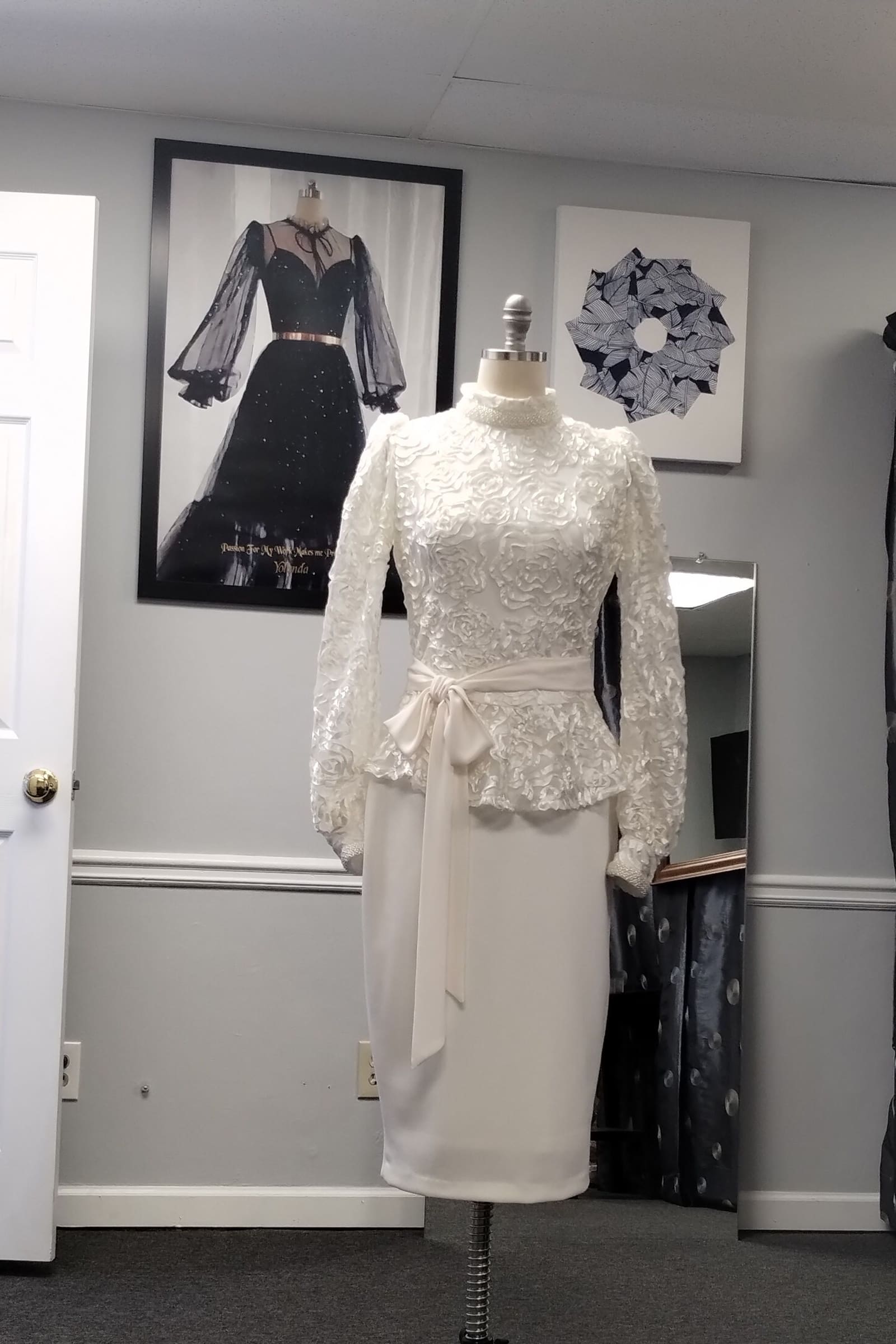 Ivory lace long-sleeve peplum top and pencil skirt on a dress form
